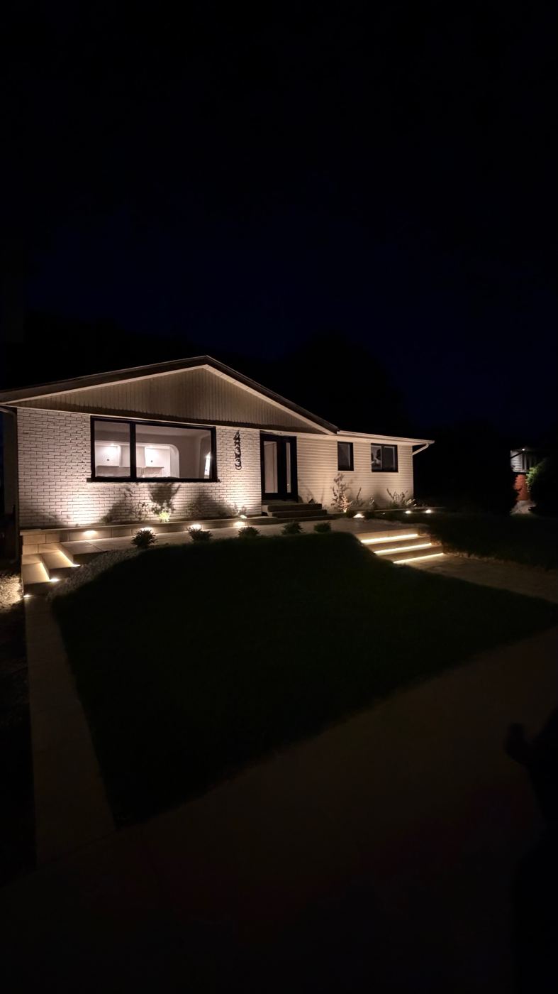 La même maison le soir, avec éclairage paysager