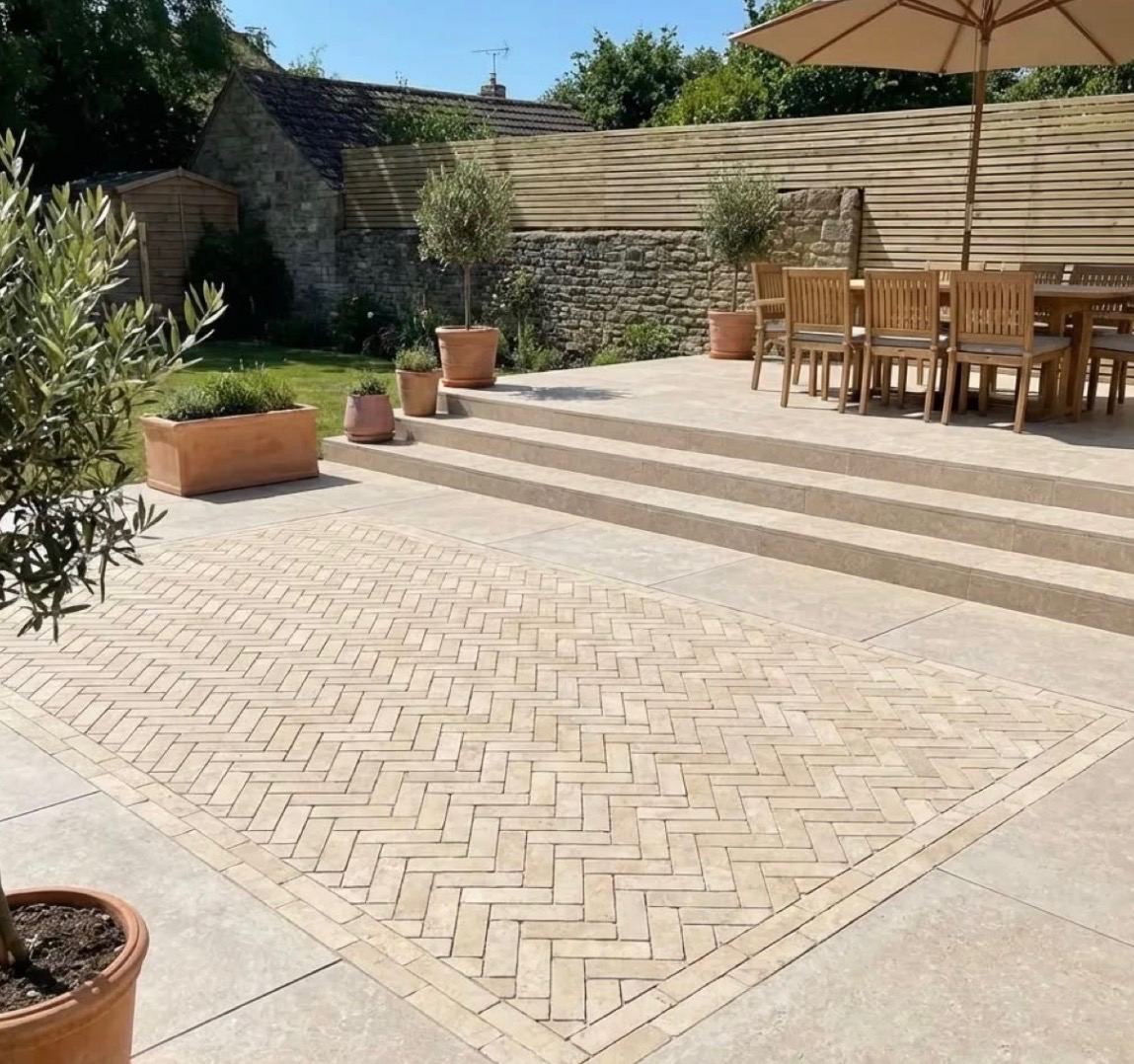 Terrasse en pavé posé en chevrons avec marches et salle à manger extérieure
